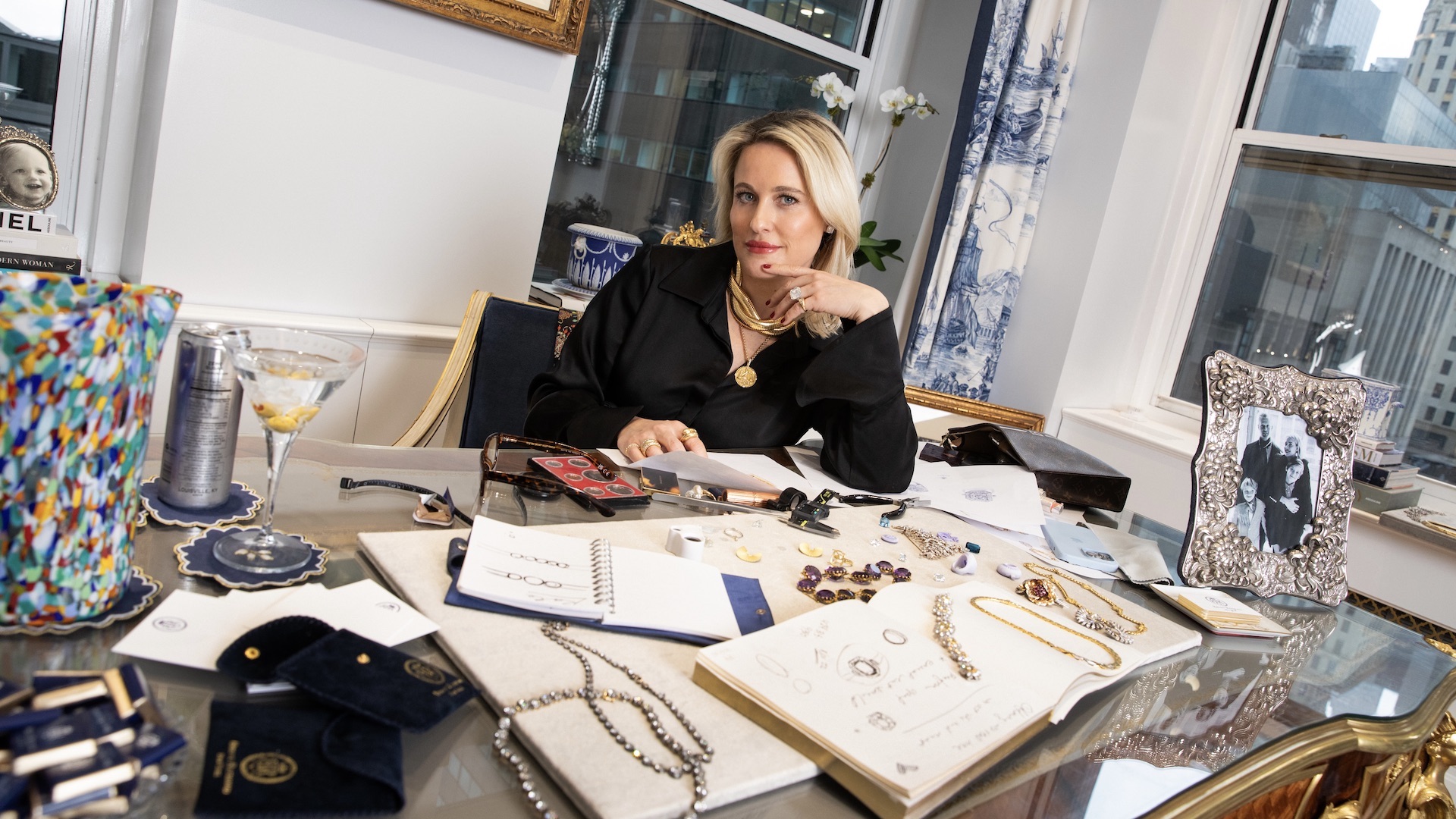 Briony Raymond at her desk with sketches and jewelry