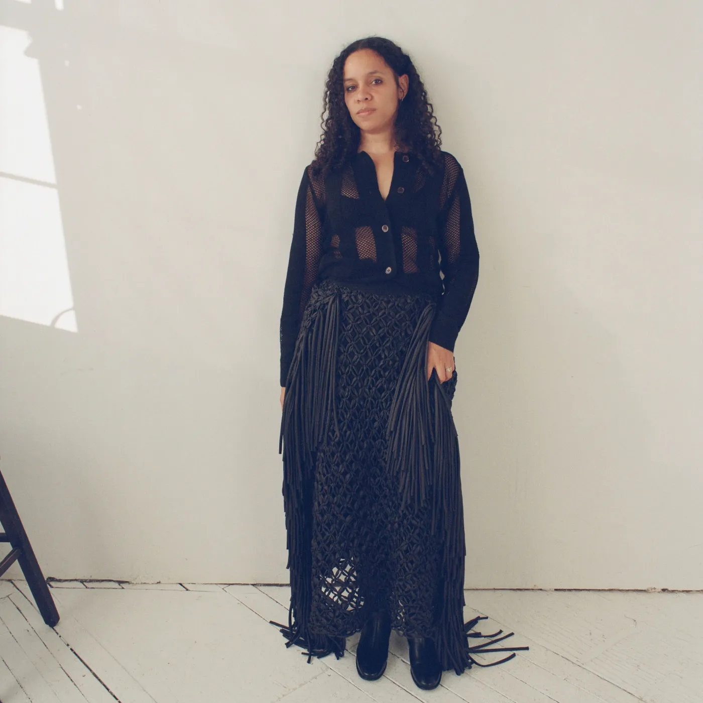 Rachel Scott in a black mesh shirt and macramé skirt