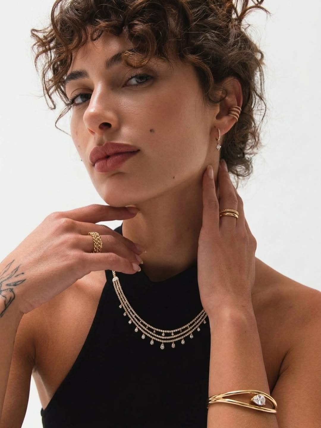 Model wearing layered diamond and gold jewelry